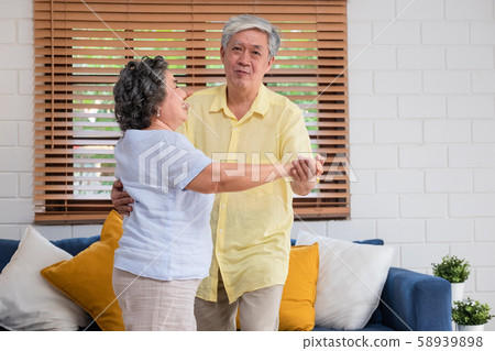 asian seniors couple enjoy dancing in living room at home.aging at home concept asian seniors couple enjoy dancing in living room at home.aging at home concept 58939898