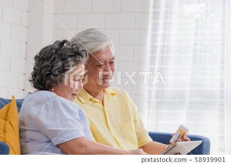Asian senior couple use tablet video conference with doctor about pill Asian senior couple use tablet video conference with doctor about pill 58939901