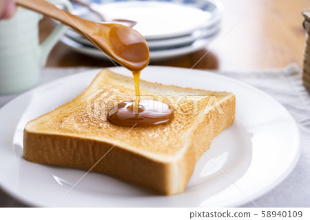 將麥盧卡蜂蜜塗在烤麵包上 58940109