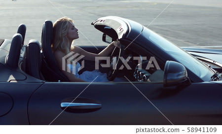 Fashion portrait of dreamy woman in the luxury car. No retouch. 58941109