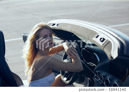 Fashion portrait of dreamy woman in the luxury car. No retouch. 58941140