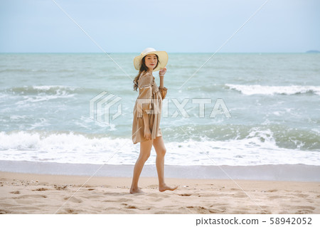 Travel woman walking on beach 58942052