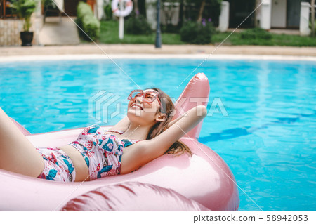 Bikini woman relaxation on pool float 58942053