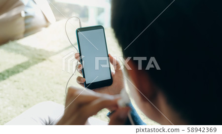 Young man relaxing listening the music from mobile Young man relaxing listening the music from mobile 58942369