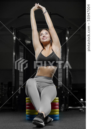pretty caucasian fitness woman pumping up muscles 58947004