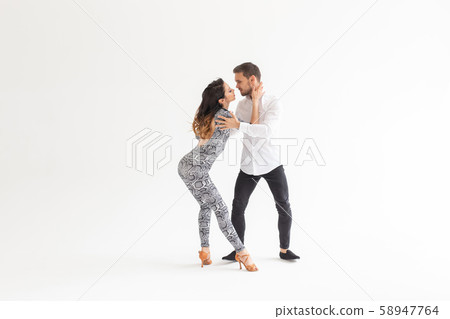 Skillful dancers performing in the white background with copy space. Sensual couple performing an Skillful dancers performing in the white background with copy space. Sensual couple performing an 58947764