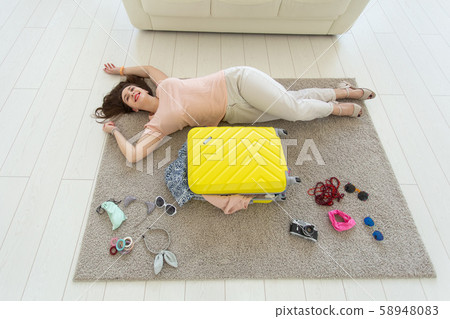 Holidays, voyage and people concept - Young beautiful woman packs a suitcase on a summer travel, top 58948083