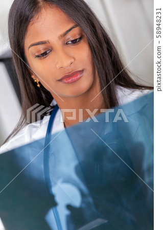 Asian Indian Female Woman Hospital Doctor Looking at an X-Ray 58948231