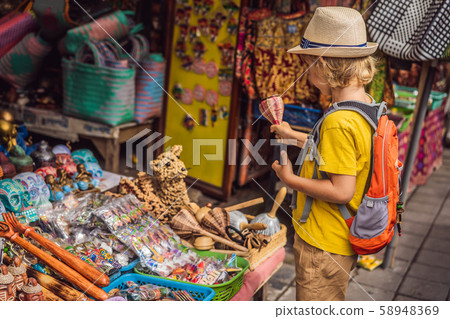 Boy at a market in Ubud, Bali. Typical souvenir shop selling souvenirs and handicrafts of Bali at 58948369