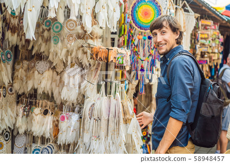 Man at a market in Ubud, Bali. Typical souvenir shop selling souvenirs and handicrafts of Bali at Man at a market in Ubud, Bali. Typical souvenir shop selling souvenirs and handicrafts of Bali at 58948457