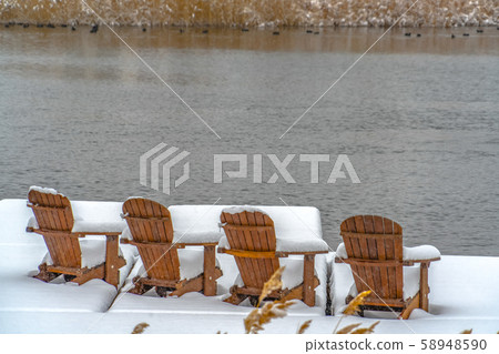 Deck on lake with wooden chairs in Daybreak Utah 58948590