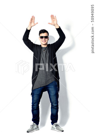 Casual young man wearing sunglasses, hands up, happy, positive a 58949895
