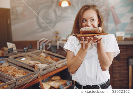 Beautiful girl buys buns at the bakery 58952302