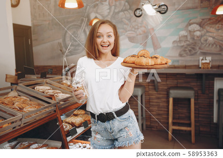 Beautiful girl buys buns at the bakery Beautiful girl buys buns at the bakery 58953363