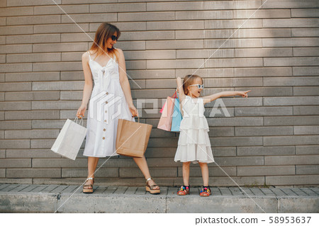 Mother and daughter with shopping bag in a city Mother and daughter with shopping bag in a city 58953637
