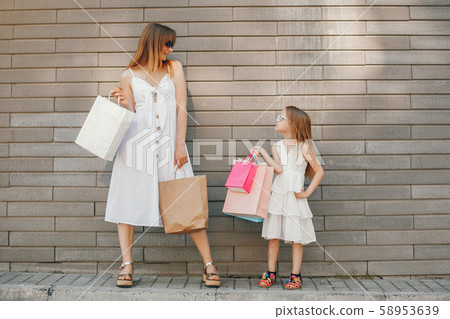 Mother and daughter with shopping bag in a city Mother and daughter with shopping bag in a city 58953639