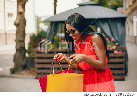 Beautiful black girl with shopping bags in a city 58955259