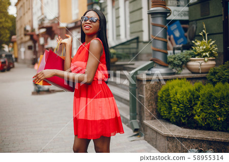 Beautiful black girl with shopping bags in a city Beautiful black girl with shopping bags in a city 58955314