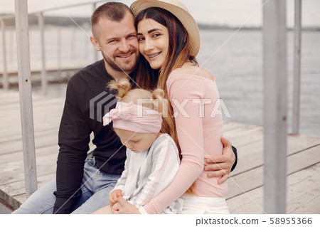 Family with daughter playing in a park Family with daughter playing in a park 58955366