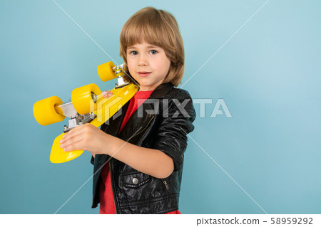 a teenage caucasian boy holds a yellow penny in hands, picture isolated on blue background a teenage caucasian boy holds a yellow penny in hands, picture isolated on blue background 58959292