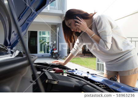 Young asian woman using mobile phone call a car Young asian woman using mobile phone call a car 58963236