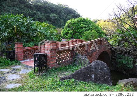 Red brick arch bridge across the creek Red brick arch bridge across the creek 58963238