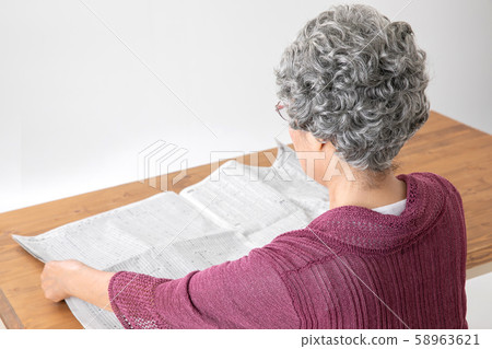 Elderly woman reading the newspaper Elderly woman reading the newspaper 58963621
