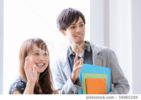 Young man and woman waving 58965289