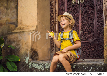 Boy tourist in Bali in cozy streets of Ubud. Bali is a popular tourist destination. Travel to Bali Boy tourist in Bali in cozy streets of Ubud. Bali is a popular tourist destination. Travel to Bali 58965804