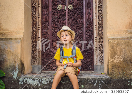 Boy tourist in Bali in cozy streets of Ubud. Bali is a popular tourist destination. Travel to Bali Boy tourist in Bali in cozy streets of Ubud. Bali is a popular tourist destination. Travel to Bali 58965807