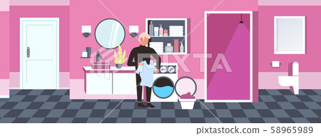 man doing housework guy loading clothes in washing machine cleaning service concept modern bathroom 58965989