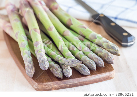 Bunch of fresh green asparagus on a wooden board Bunch of fresh green asparagus on a wooden board 58966251