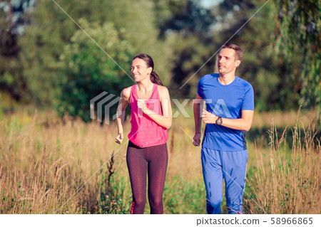 Active sportive couple running in park. Health and fitness. 58966865