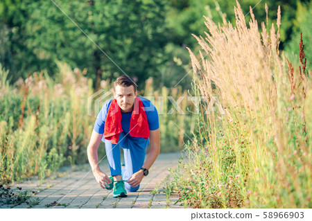 Sportive young man doing sport exercises outdoors in the park Sportive young man doing sport exercises outdoors in the park 58966903
