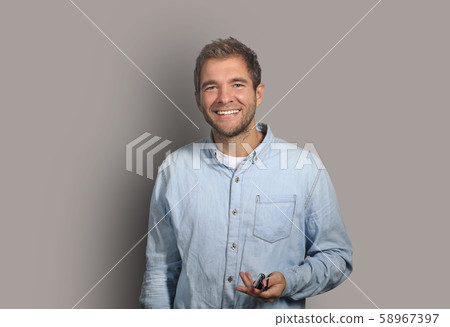 Young man in denim shirt is smiling Young man in denim shirt is smiling 58967397