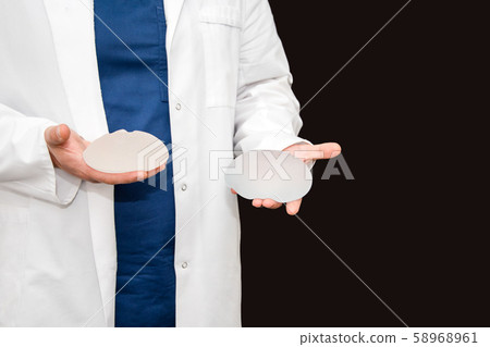 Doctor holding silicone implant for breast Doctor holding silicone implant for breast 58968961