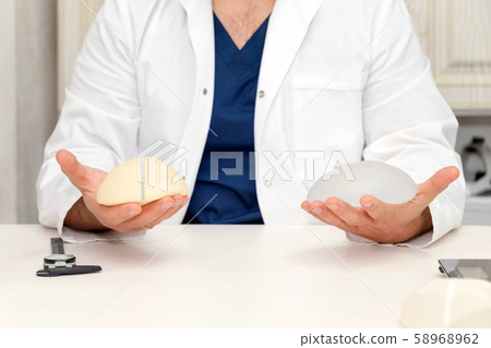 Doctor holding silicone implant for breast 58968962