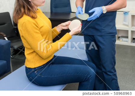 Woman planning to have a breast implant. Doctor Woman planning to have a breast implant. Doctor 58968963