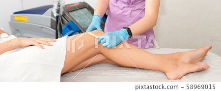 Laser epilation on beautiful female legs at beauty Laser epilation on beautiful female legs at beauty 58969015