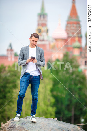Happy young urban man drinking coffee in european city. 58970093