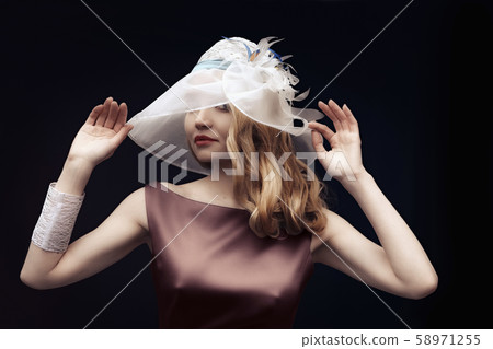 Beautiful lady in silk dress and wide hat posing Beautiful lady in silk dress and wide hat posing 58971255
