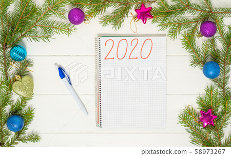 New Year's goals with colorful decorations and christmas tree branches on the white wooden table. New Year's goals with colorful decorations and christmas tree branches on the white wooden table. 58973267