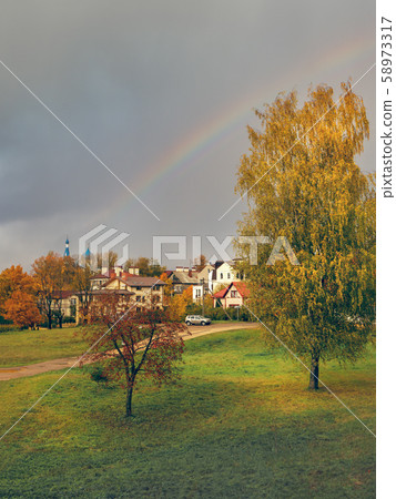 Rainbow over the village in autumn. Rainbow over the village in autumn. 58973317