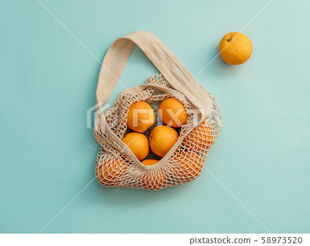 Mesh bag with fruits on blue background.Zero waste Mesh bag with fruits on blue background.Zero waste 58973520