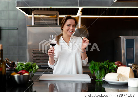 Beautiful young caucasian girl standing in kitchen Beautiful young caucasian girl standing in kitchen 58974198