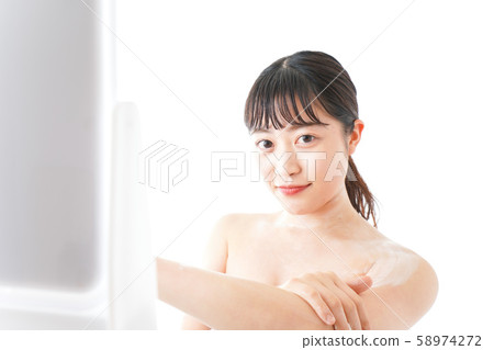 年輕女子在皮膚上應用霜 58974272