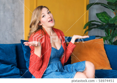 Puzzled young adult blonde woman with arms out, Puzzled young adult blonde woman with arms out, 58974451