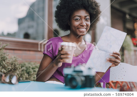 Beautiful lady smiling holding paper and cup of coffee Beautiful lady smiling holding paper and cup of coffee 58974804