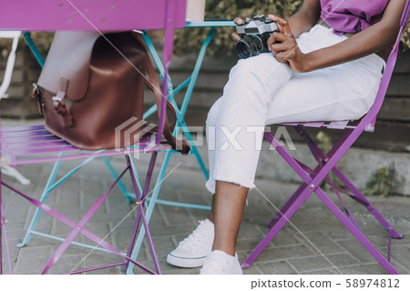 Close up of a woman legs in white jeans sitting on chair Close up of a woman legs in white jeans sitting on chair 58974812