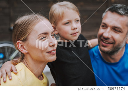 Cute little girl hugging her smiling mother and father Cute little girl hugging her smiling mother and father 58975574